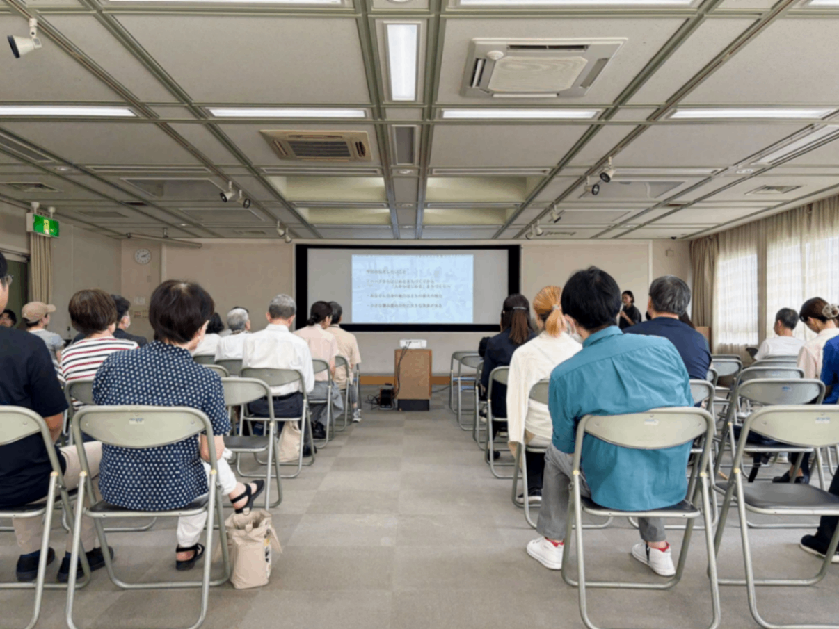写真：スクリーンに投影したスライドを見る参加者